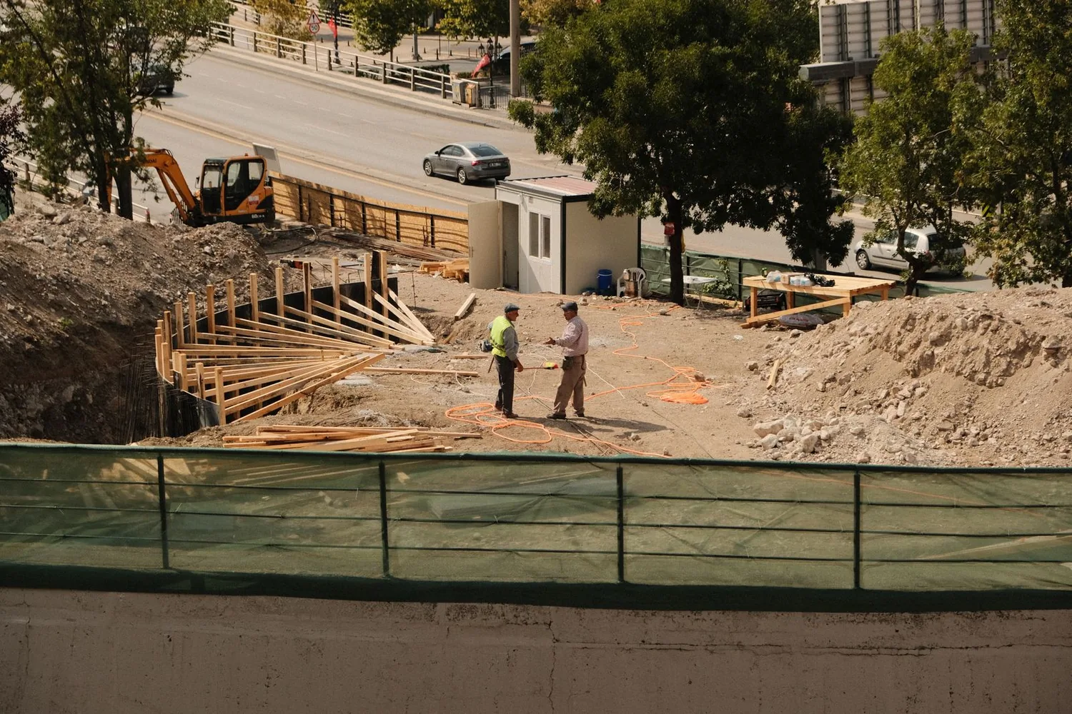 Two engineers discussing plans at an active construction site