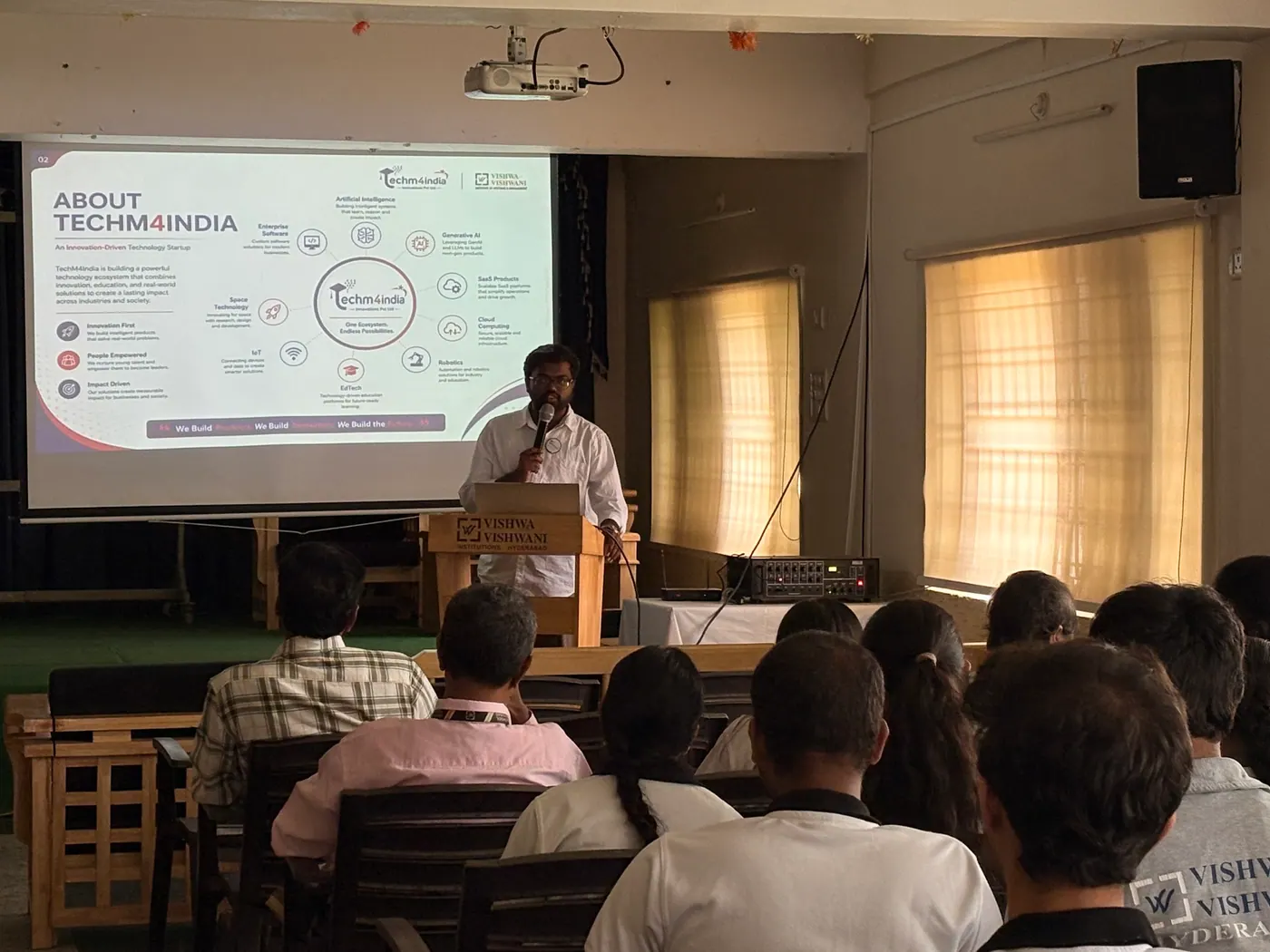 Students in a seminar hall during an 'About TechM4India' presentation