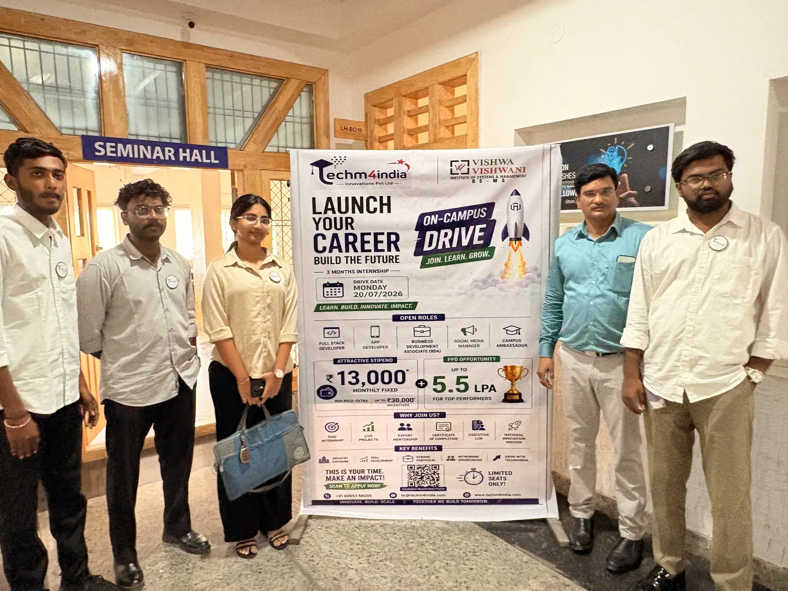 The TechM4India team with students beside a 'Launch your career' on-campus drive standee in a seminar hall