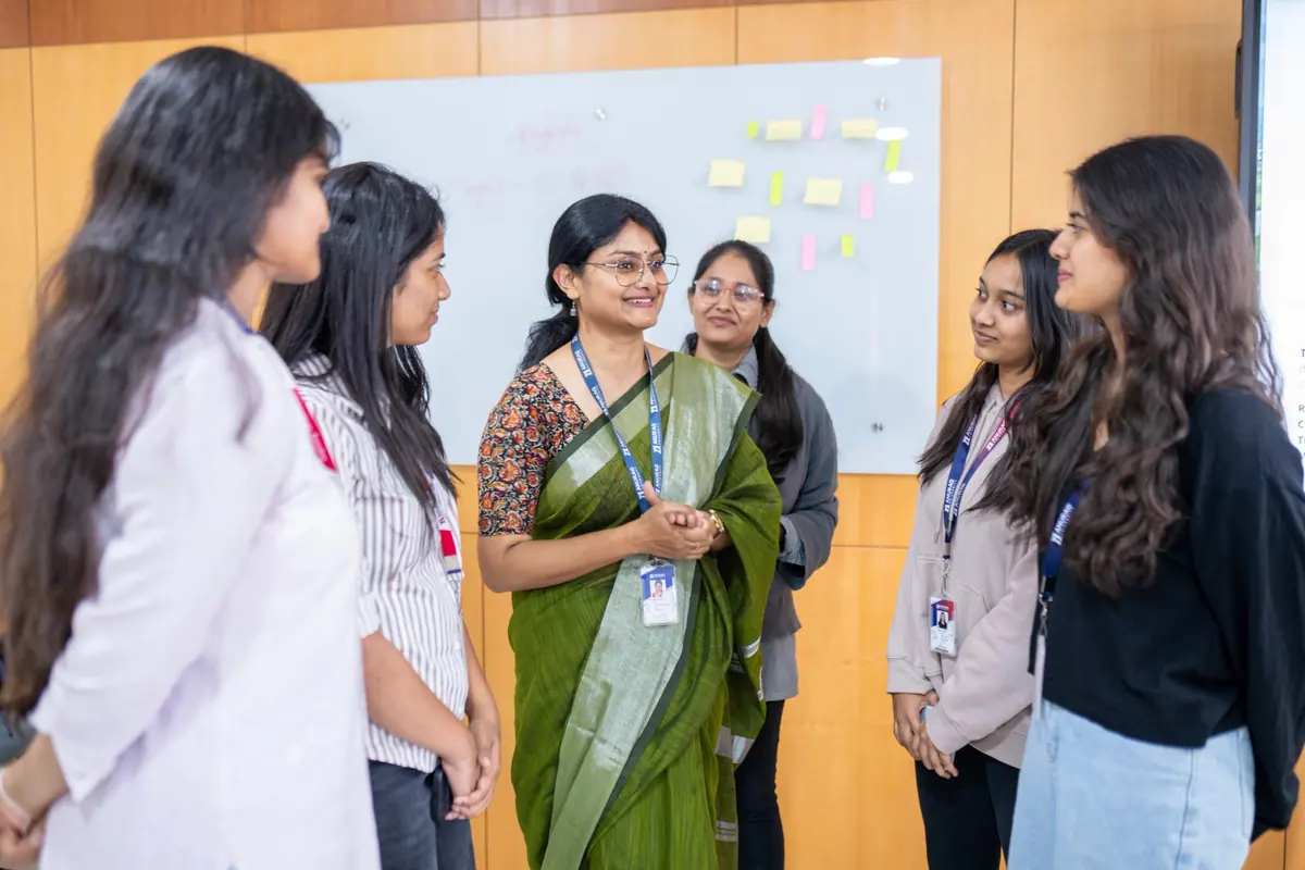A faculty mentor talking with a group of students