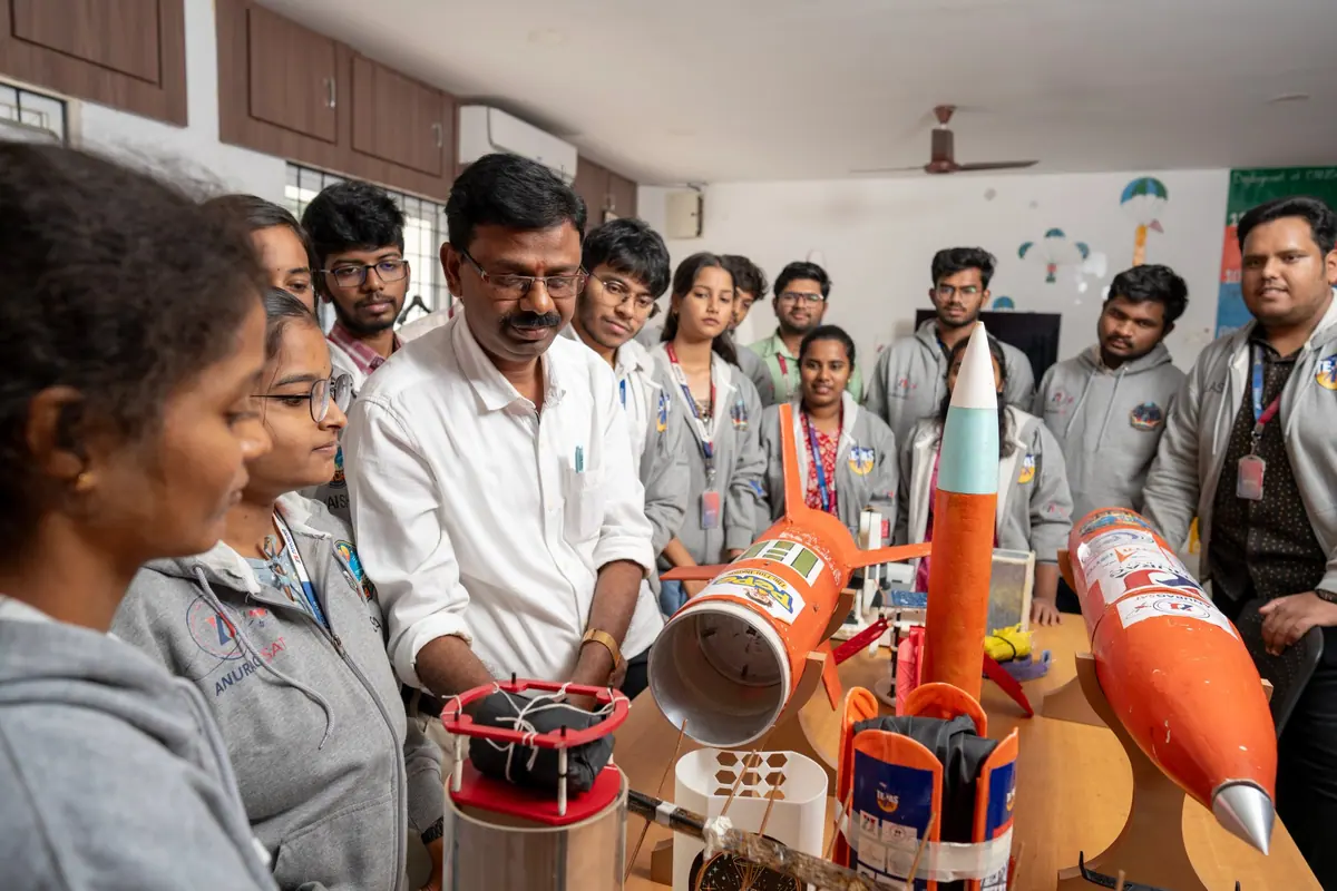 Students and a mentor with rocket models built in a student project