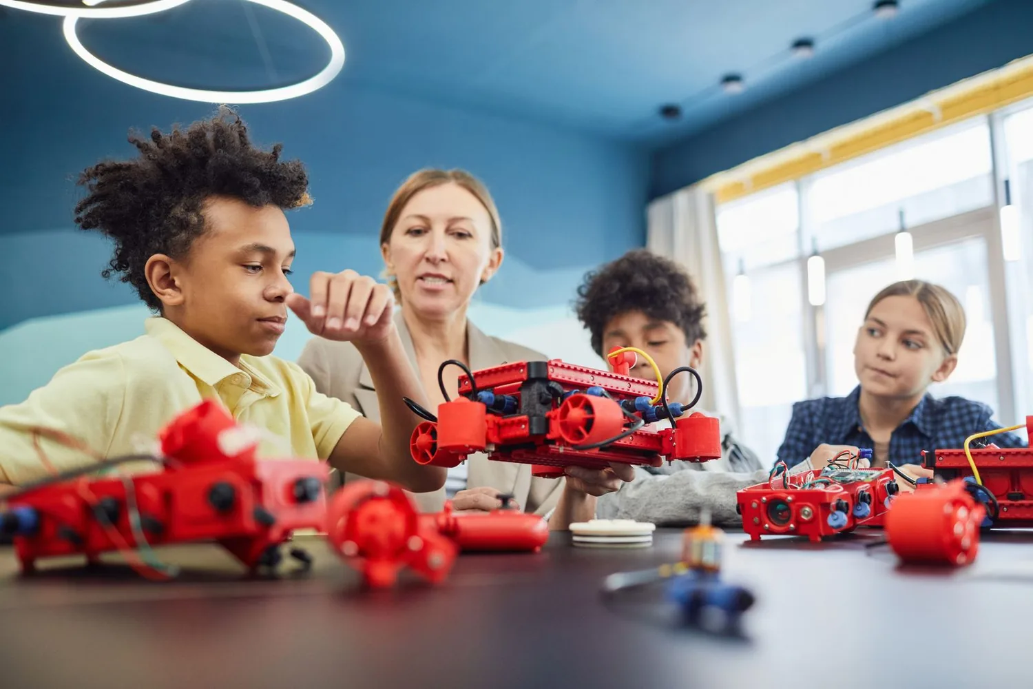 Illustrative photograph of students and an educator building a robotics project